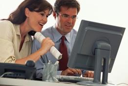 Woman and man sitting in front of a monitor