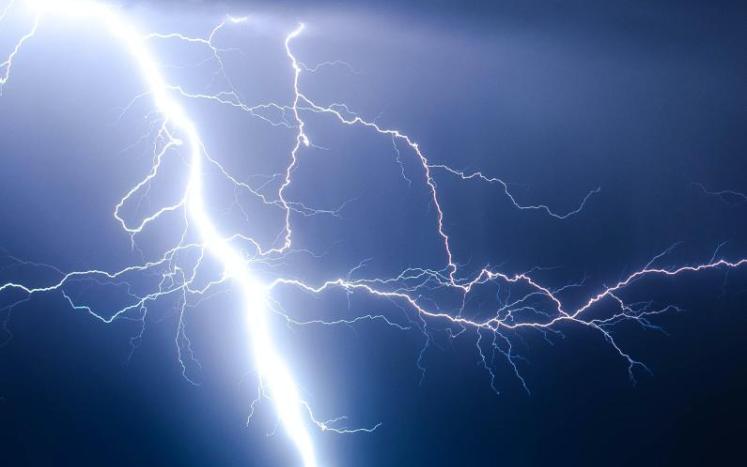 Lightning strike during blue sky